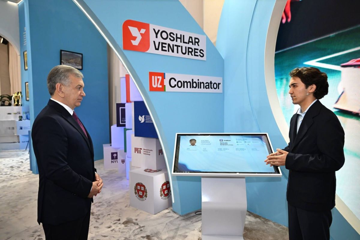 Asilbek Ashurov presenting Makon AI to President of Uzbekistan Shavkat Mirziyoyev